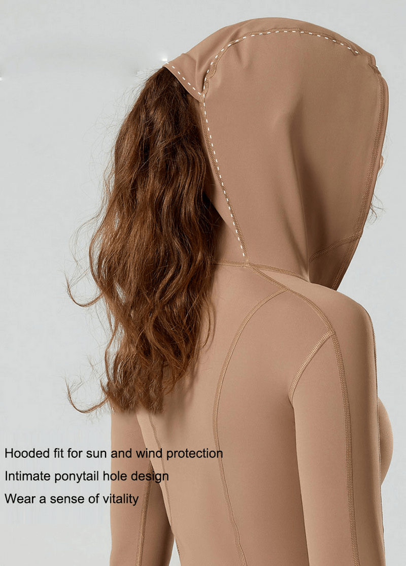 Stylish yoga top with long sleeves, hood, and ponytail hole in beige. Perfect for workouts with breathable and quick-dry fabric.